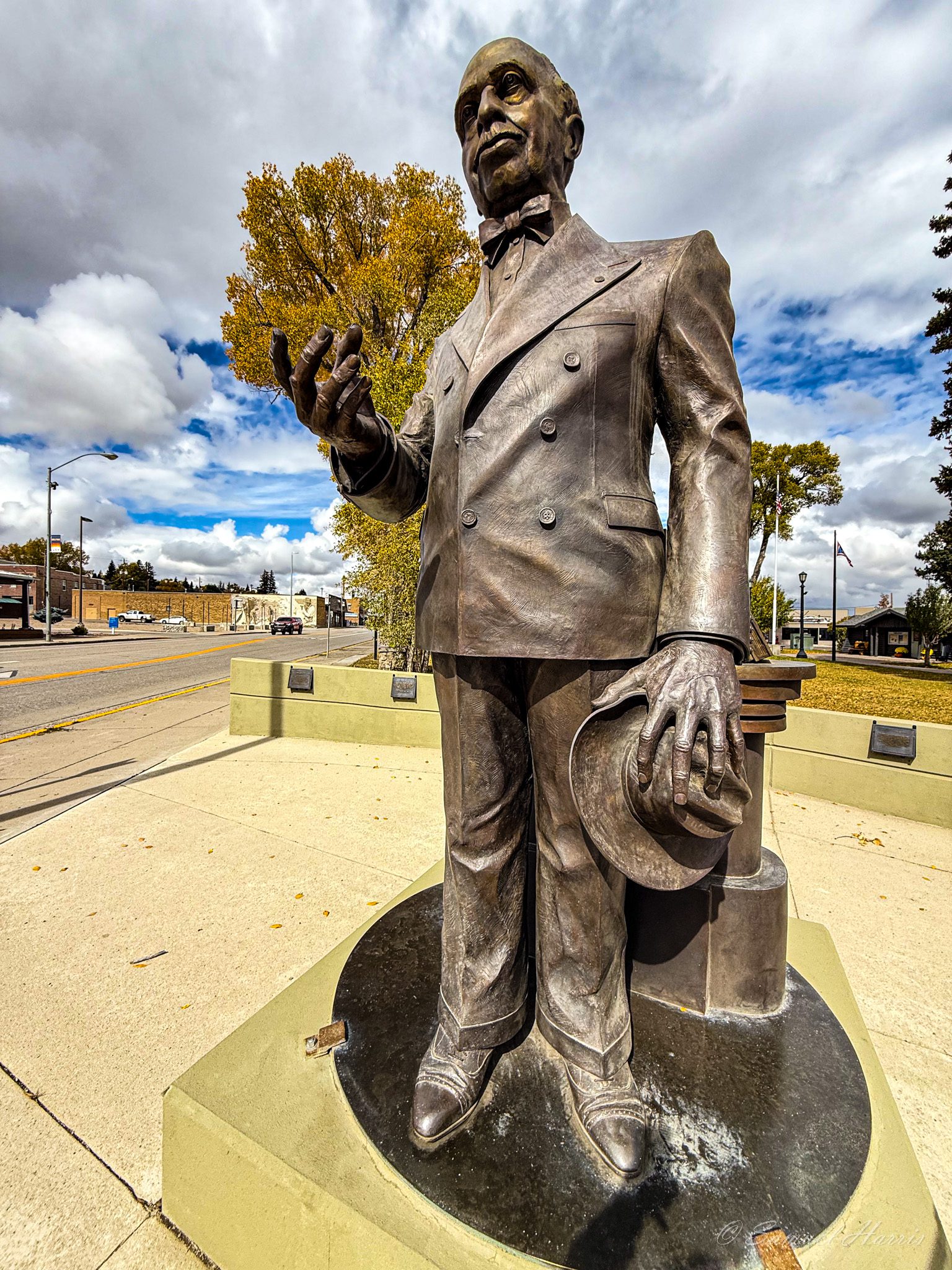 Bronze statue of a man holding hat.